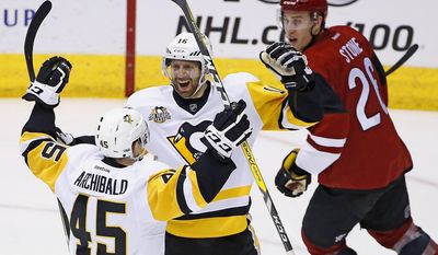 Pittsburgh Penguins right wing Josh Archibald (45) celebrates his goal with center Eric Fehr (16) as Arizona Coyotes defenseman Michael Stone, right, looks on during the second period of an NHL hockey game, Saturday, Feb. 11, 2017, in Glendale, Ariz. (AP Photo/Ross D. Franklin)
