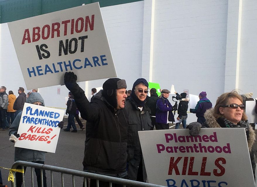 Abortion opponents rally outside Planned Parenthood in St. Paul, Minn., on Saturday, Feb. 11, 2017. Rallies aimed at urging Congress and President Donald Trump to end federal funding for Planned Parenthood are scheduled across the country. (AP Photo/Jeff Baenen)