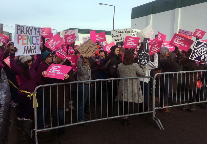 Supporters of Planned Parenthood hold counter protest as abortion opponents demonstrate outside Planned Parenthood in St. Paul, Minn., on Saturday, Feb. 11, 2017. Rallies aimed at urging Congress and President Donald Trump to end federal funding for Planned Parenthood are scheduled across the country. (AP Photo/Jeff Baenen)
