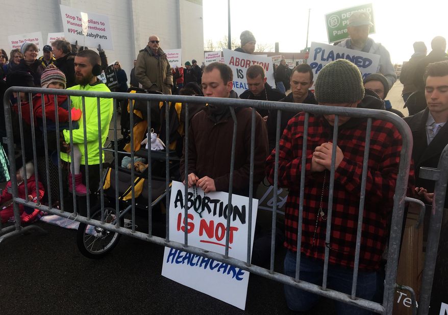 Abortion opponents pray and protest outside Planned Parenthood in St. Paul, Minn., on Saturday, Feb. 11, 2017. Rallies aimed at urging Congress and President Donald Trump to end federal funding for Planned Parenthood are scheduled across the country. (AP Photo/Jeff Baenen)