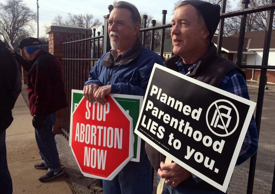 Marvin Naegele, 62, of Walnut, Iowa, left, and Lon Schroeder, 61, of Council Bluffs hold protest signs during a protest on Saturday, Feb. 11, 2017, in Council Bluffs, Iowa. Rallies aimed at urging Congress and President Donald Trump to end federal funding for Planned Parenthood are scheduled across the country. (AP Photo/Margery Beck) **FILE**