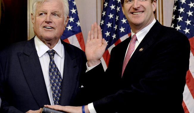 FILE - In this Jan. 6, 2009, file photo, Sen. Edward M. Kennedy, D-Mass., left, holds a Bible during the mock swearing-in ceremony for his son, Rep. Patrick Kennedy, D-R.I., on Capitol Hill in Washington. In a February 2017 interview with the Associated Press, former Rep. Patrick Kennedy speaks about the Donald Trump presidency and what his late father may have thought about it. (AP Photo/Susan Walsh, File)