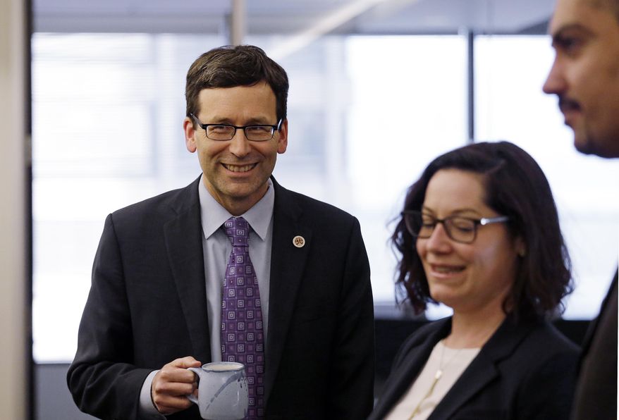 Washington Attorney General Bob Ferguson smiles as he speaks with staff members in a hallway before a news conference about a federal appeals court's refusal to reinstate President Donald Trump's ban on travelers from seven predominantly Muslim nations, Thursday, Feb. 9, 2017, in Seattle. The ruling dealt another legal setback to the new administration's immigration policy. In a unanimous decision, the panel of three judges from the San Francisco-based 9th U.S. Circuit Court of Appeals declined to block a lower-court ruling that suspended the ban and allowed previously barred travelers to enter the U.S. An appeal to the U.S. Supreme Court is possible. (AP Photo/Elaine Thompson)
