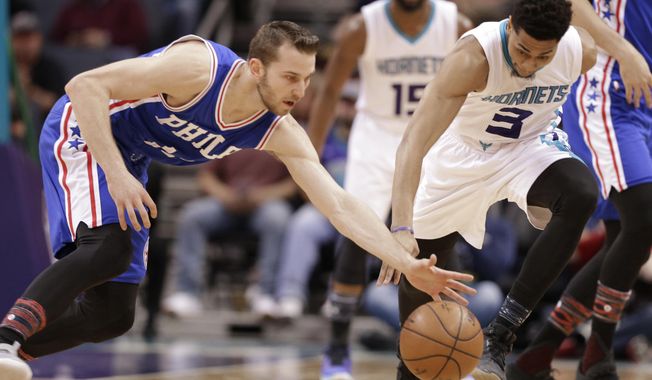 Charlotte Hornets&#x27; Jeremy Lamb (3) and Philadelphia 76ers&#x27; Nik Stauskas (11) chase a loose ball in the first half of an NBA basketball game in Charlotte, N.C., Monday, Feb. 13, 2017. (AP Photo/Chuck Burton)