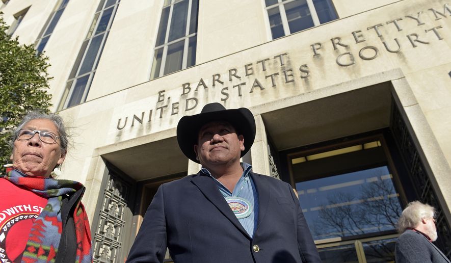 Cheyenne River Sioux Chairman Harold Frazier, center, and Madonna Thunder Hawk, left, of the Oohenumpa band of the Cheyenne River Sioux Tribe, wait to speak to reporters outside federal court in Washington, Monday, Feb. 13, 2017. A judge has rejected a request by two American Indian tribes to halt construction of the remaining section of the Dakota Access oil pipeline until their lawsuit over the project is resolved. (AP Photo/Susan Walsh)