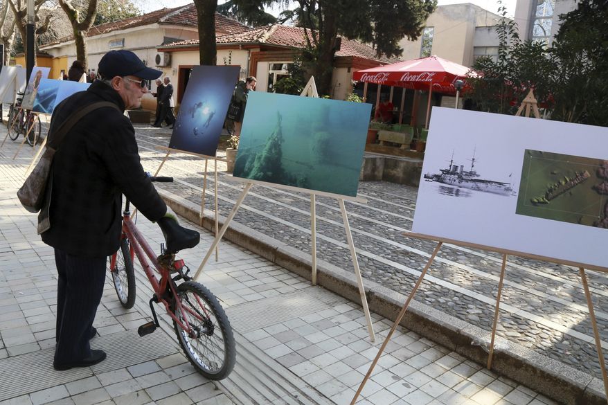 An elderly man looks the exhibition by The Albanian National Coastline Agency, in Tirana, on Monday, Feb. 13, 2017 showing underwater finds of potential archaeological significance.Albania is promoting the archaeological finds in the waters off its southwest coast to raise public interest and to attract attention of decision-makers who can help preserve the discoveries. (AP Photo Hektor Pustina)