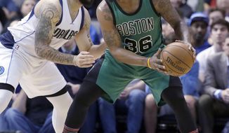 Boston Celtics guard Marcus Smart (36) keeps the ball from Dallas Mavericks guard Deron Williams (8) during the first half of an NBA basketball game in Dallas, Monday, Feb. 13, 2017. (AP Photo/LM Otero)