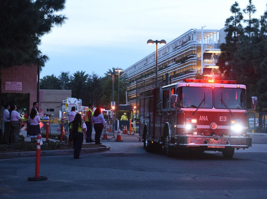 Emergency personnel respond to parking structure after several cars caught fire in Anaheim, Calif., Monday, Feb. 13, 2017. Several cars were destroyed or damaged by fires in the main parking structure Monday at Disneyland, authorities said. (Kyusung Gong/The Orange County Register via AP)