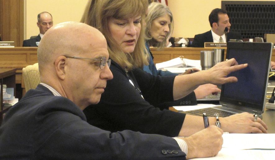 J.G. Scott, left, the chief fiscal analyst for the Kansas Legislative Research Department, confers with Bobbi Mariani, another fiscal analyst, during a meeting of the Kansas House Appropriations Committee, Monday, Feb. 13, 2017, at the Statehouse in Topeka, Kan. The committee has endorsed budget-balancing proposals that would allow the state to avoid cuts in education funding. (AP Photo/John Hanna)