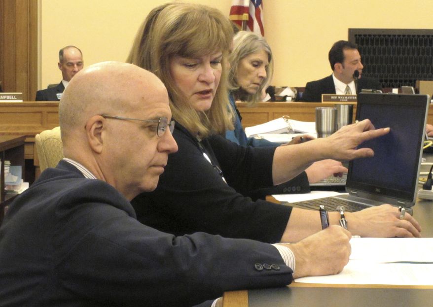 J.G. Scott, left, the chief fiscal analyst for the Kansas Legislative Research Department, confers with Bobbi Mariani, another fiscal analyst, during a meeting of the Kansas House Appropriations Committee, Monday, Feb. 13, 2017, at the Statehouse in Topeka, Kan. The committee has endorsed budget-balancing proposals that would allow the state to avoid cuts in education funding. (AP Photo/John Hanna)
