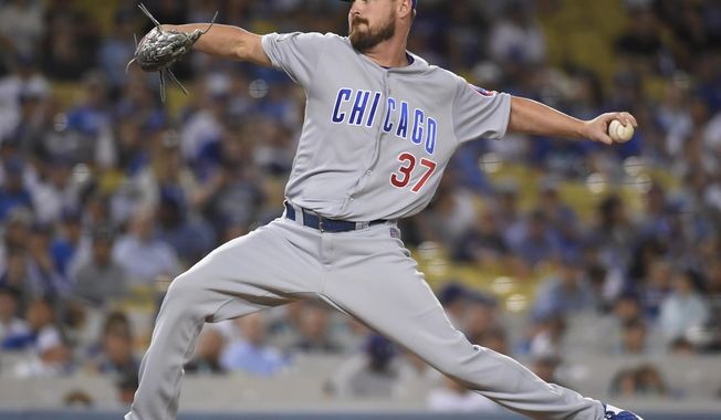 FILE- This Oct. 19, 2016 file photo shows Chicago Cubs relief pitcher Travis Wood throwing during the seventh inning of Game 4 of the National League baseball championship series against the Los Angeles Dodgers in Los Angeles. A person familiar with the deal says the Kansas City Royals and left-hander Travis Wood have agreed to a $12 million, two-year contract. The person spoke to The Associated Press on condition of anonymity Monday, Feb. 13, 2017 because the deal is pending a physical. (AP Photo/Mark J. Terrill)