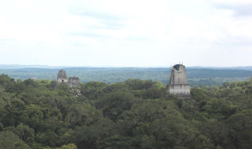 In this photograph taken Dec. 6, 2016, three of Tikal National Park's temples rise above the tree line as viewed from the top of another temple, Temple IV. The sprawling park in northern Guatemala is one of the country's top travel attractions, showcasing the Mayan civilization's engineering feats. (AP Photo/Manuel Valdes)