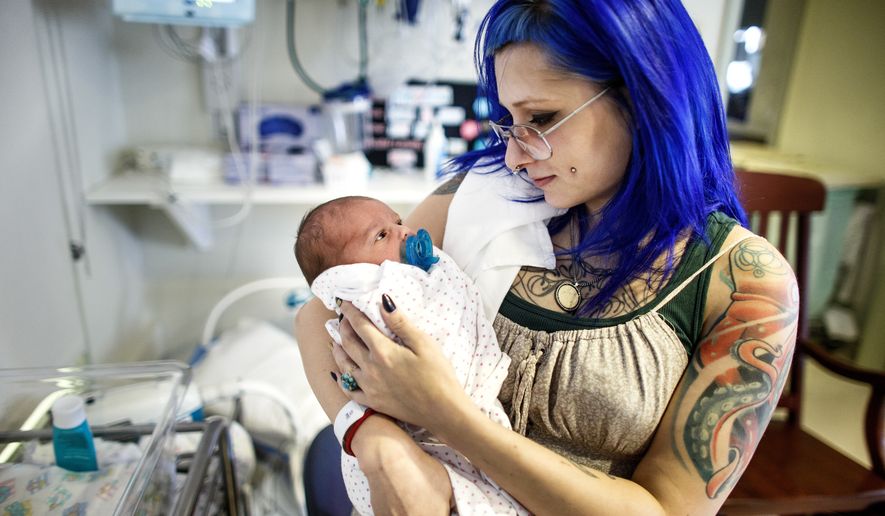 ADVANCE FOR USE SATURDAY, FEB. 18 - In this Feb. 7, 2017 photo, Logan Keck, 23, of Carlisle, holds her daughter, born Feb. 1, in the NICU unit at Holy Spirit-Geisinger in East Pennsboro Township, Pa. Keck was initially addicted to heroin and was in recovery for two years on methadone maintenance treatment when she found out she was pregnant. Keck&#39;s baby is now on morphine to help her through withdrawal. (Dan Gleiter/PennLive.com via AP)