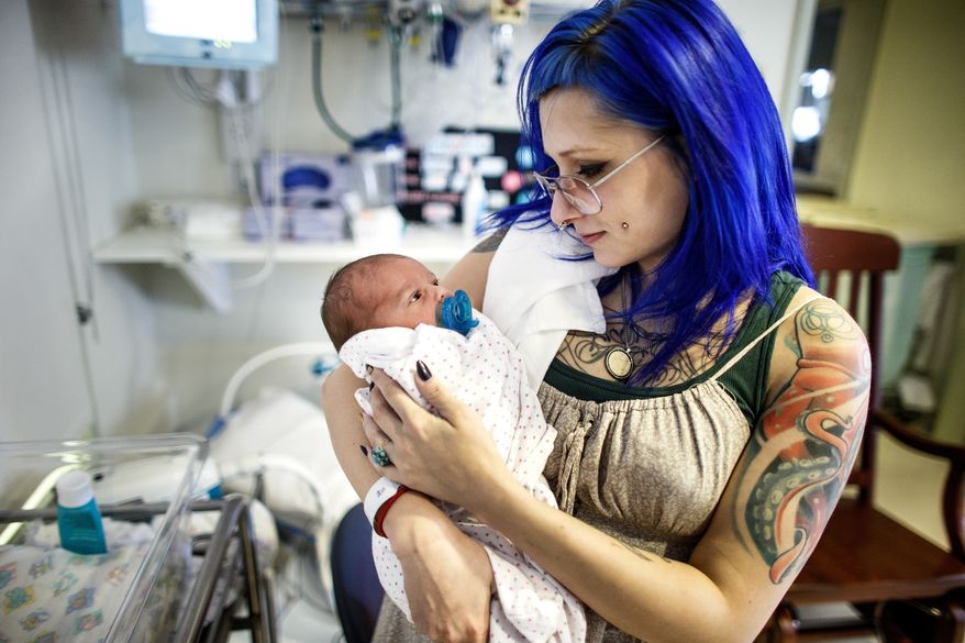 ADVANCE FOR USE SATURDAY, FEB. 18 - In this Feb. 7, 2017 photo, Logan Keck, 23, of Carlisle, holds her daughter, born Feb. 1, in the NICU unit at Holy Spirit-Geisinger in East Pennsboro Township, Pa. Keck was initially addicted to heroin and was in recovery for two years on methadone maintenance treatment when she found out she was pregnant. Keck's baby is now on morphine to help her through withdrawal. (Dan Gleiter/PennLive.com via AP)