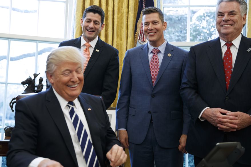 President Donald Trump, jokes with, from left, House Speaker Paul Ryan of Wis., Rep. Sean Duffy, R-Wis., and Rep. Peter King, R-N.Y. in the Oval Office of the White House in Washington, Tuesday, Feb. 14, 2017, after the president signed House Joint Resolution 41. (AP Photo/Evan Vucci) ** FILE **
