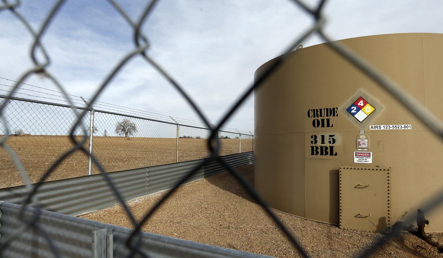 FILE - In this Feb. 13, 2017 file photo, a crude oil storage tank sits behind a fence at a petroleum extraction site, a few miles from the border of Boulder County, in Weld County, near Mead, Colorado. Colorado Attorney General Cynthia Coffman asked a state court Tuesday, Feb. 14, 2017 to overturn Boulder County's moratorium on oil and gas drilling, saying it violates state law and a state Supreme Court ruling. (AP Photo/Brennan Linsley, file)