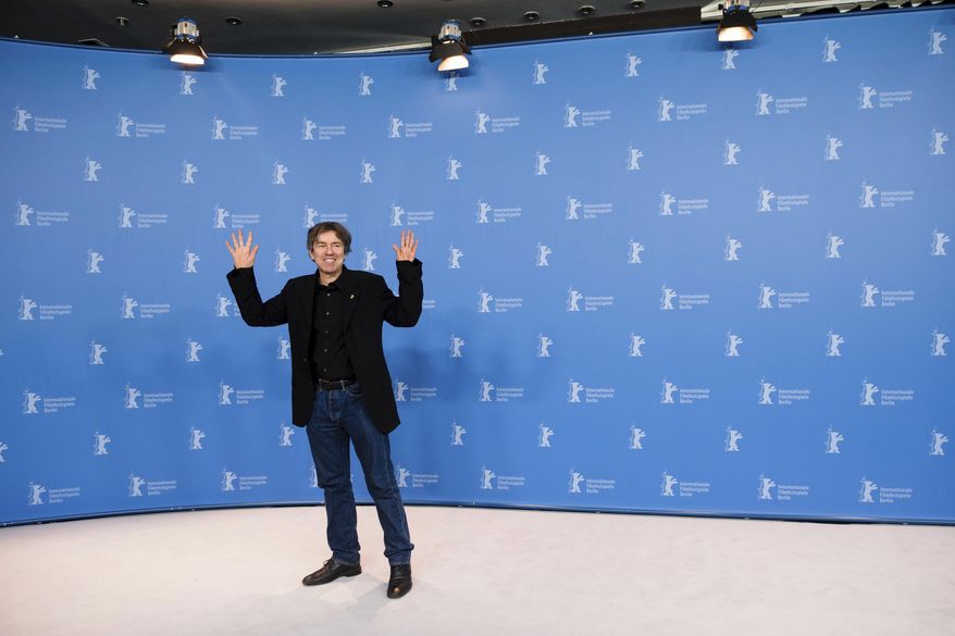 Director Andres Veiel raises his arms during a photo call for the competition film 'Beuys' at the 2017 Berlinale Film Festival in Berlin Tuesday, Feb. 14, 2017. (Gregor Fischer/dpa via AP)