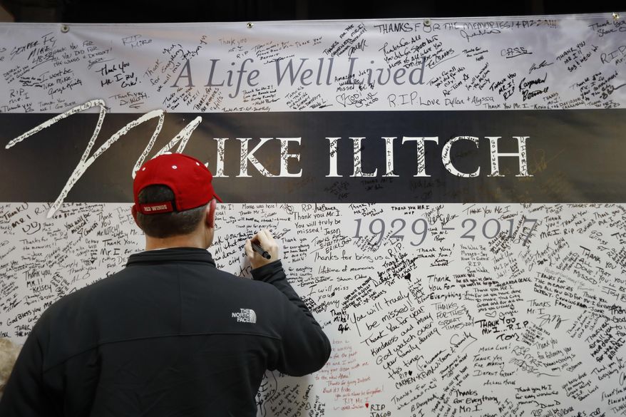 A well wisher signs a card for Mike Ilitch at Joe Louis Arena before an NHL hockey game between the Detroit Red Wings and St. Louis Blues, Wednesday, Feb. 15, 2017, in Detroit. Billionaire businessman Ilitch, who founded the Little Caesars pizza empire before buying the Detroit Red Wings and Detroit Tigers died Friday. He was 87. (AP Photo/Paul Sancya)