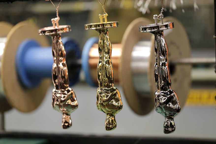 Oscar statuettes in various stages of the coating process are hung together at Epner Technology in the Brooklyn borough of New York, Tuesday, Jan. 17, 2017. Each statuette is coated in three layers - the final one the iconic gold - and every Oscar fist-pumped or tearfully cradled by Academy Award winners is first cast, buffed and fussed over by people far from Hollywood who have spent the last several months making 60 identical gold Oscars for the Feb. 26th awards. (AP Photo/Seth Wenig)