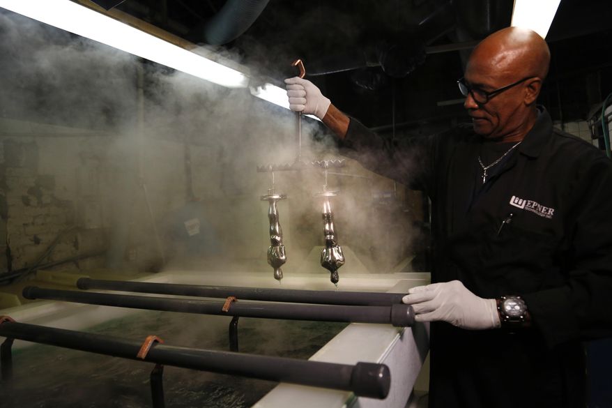 Cecil Bowen works on Oscar statuettes that have already been nickel plated at Epner Technology in the Brooklyn borough of New York, Tuesday, Jan. 17, 2017. Each statuette is coated in three layers - the final one the iconic gold - and every Oscar fist-pumped or tearfully cradled by Academy Award winners is first cast, buffed and fussed over by people far from Hollywood who have spent the last several months making 60 identical gold Oscars for the Feb. 26th awards. (AP Photo/Seth Wenig)