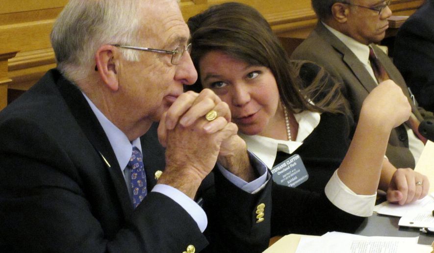 Kansas state Rep. Jim Karleskint, left, R-Tonganoxie, confers with Rep. Stephanie Clayton, center, R-Overland Park, during a House committee discussion on preventing concealed guns in public hospitals, Wednesday, Feb. 15, 2017, at the Statehouse in Topeka, Kan. Sitting to their right is Rep. Broderick Henderson, D-Kansas City (AP Photo/John Hanna)
