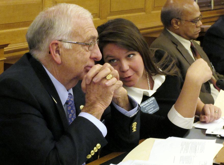 Kansas state Rep. Jim Karleskint, left, R-Tonganoxie, confers with Rep. Stephanie Clayton, center, R-Overland Park, during a House committee discussion on preventing concealed guns in public hospitals, Wednesday, Feb. 15, 2017, at the Statehouse in Topeka, Kan. Sitting to their right is Rep. Broderick Henderson, D-Kansas City (AP Photo/John Hanna)