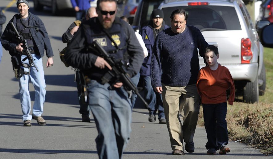 FILE - In this Friday, Dec. 14, 2012 file photo, parents leave a staging area after being reunited with their children following a shooting at the Sandy Hook Elementary School in Newtown, Conn., where Adam Lanza fatally shot 27 people, including 20 children. The Republican-led Senate voted Wednesday, Feb. 15, 2017, to block an Obama-era regulation that would prevent an estimated 75,000 people with mental disorders from being able to purchase a firearm. (AP Photo/Jessica Hill, File)