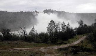 A trail runs along the Feather River as water gushes from the Oroville Dam&#39;s main spillway Wednesday, Feb. 15, 2017, in Oroville, Calif. The Oroville Reservoir is continuing to drain Wednesday as state water officials scrambled to reduce the lake&#39;s level ahead of impending storms. (AP Photo/Marcio Jose Sanchez)