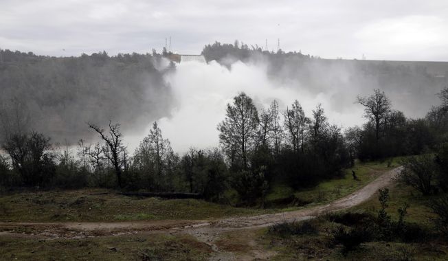 A trail runs along the Feather River as water gushes from the Oroville Dam&#x27;s main spillway Wednesday, Feb. 15, 2017, in Oroville, Calif. The Oroville Reservoir is continuing to drain Wednesday as state water officials scrambled to reduce the lake&#x27;s level ahead of impending storms. (AP Photo/Marcio Jose Sanchez)