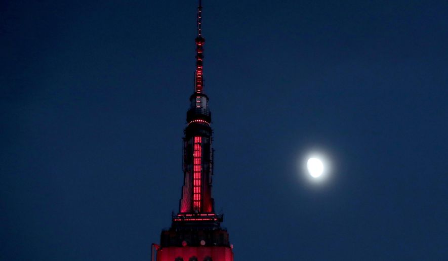 FILE - In this Thursday, Nov. 10, 2016, file photo, the moon is seen in its waxing gibbous stage as it rises near the Empire State Building, in New York. On Wednesday, Feb. 15, 2017, the Federal Reserve Bank of New York issues its Empire State manufacturing index for February. (AP Photo/Julio Cortez, File)