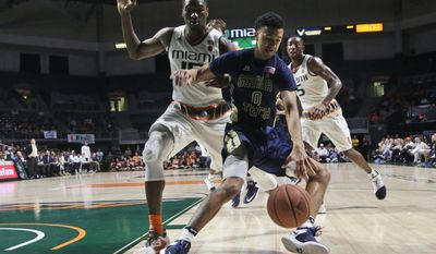 Georgia Tech&#39;s Justin Moore (0) loses control of the ball as Miami&#39;s Ebuka Izundu defends during the first half of an NCAA college basketball game, Wednesday, Feb. 15, 2017, in Coral Gables, Fla. (AP Photo/Lynne Sladky)