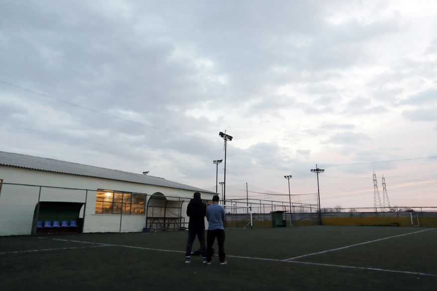 FOR STORY: GREECE TEAM CALLED HOPE - In this Sunday, Feb. 5, 2017, players of Hope Refugee Football Club pray before a soccer match in western Athens. Former Greek national soccer team goalkeeper Antonis Nikopolidis, who became a national hero in 2004 during the European Cup, is heading a project to help refugees stranded in Greece regain a sense of purpose, working as a team. On weekends they play in an amateur league against teams made up of professional groups like lawyers, telecom workers, and accountants. (AP Photo/Thanassis Stavrakis)