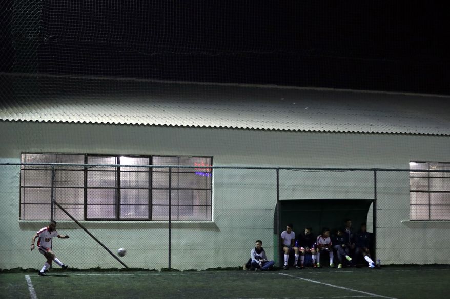 FOR STORY: GREECE TEAM CALLED HOPE - In this Sunday, Feb. 5, 2017, Syrian Hozaifa Hajdepo of Hope Refugee Football Club kicks a corner during a soccer match in western Athens. Former Greek national soccer team goalkeeper Antonis Nikopolidis, who became a national hero in 2004 during the European Cup, is heading a project to help refugees stranded in Greece regain a sense of purpose, working as a team. On weekends they play in an amateur league against teams made up of professional groups like lawyers, telecom workers, and accountants.(AP Photo/Thanassis Stavrakis)
