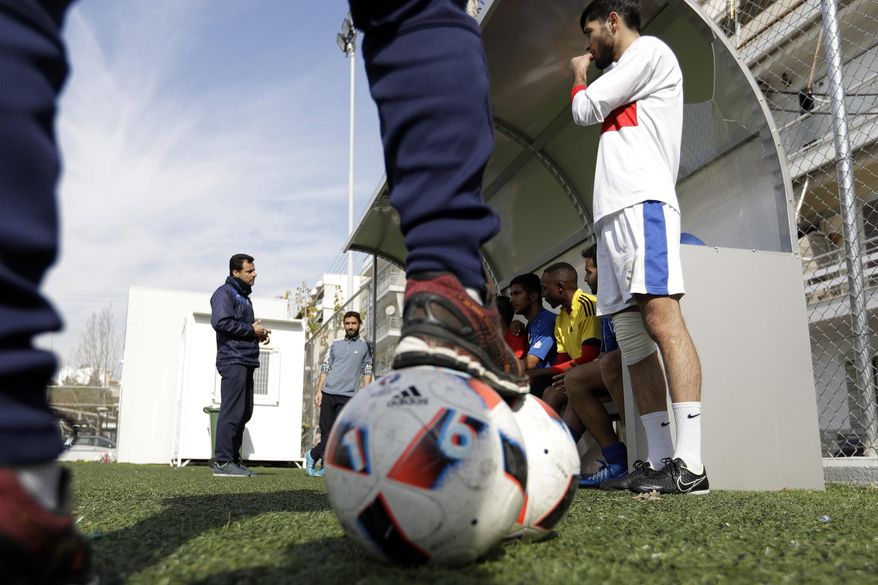 FOR STORY : GREECE TEAM CALLED HOPE : In this Wednesday, Feb. 1, 2017, Antreas Sampanis, left, coach of Hope Refugee Football Club speaks to his players during a training in Athens. Former Greek national soccer team goalkeeper Antonis Nikopolidis, who became a national hero in 2004 during the European Cup, is heading a project to help refugees stranded in Greece regain a sense of purpose, working as a team. The team is called "Hope" and is made up of players who fled warzones like Syria, Yemen, Iraq and Afghanistan. (AP Photo/Thanassis Stavrakis)