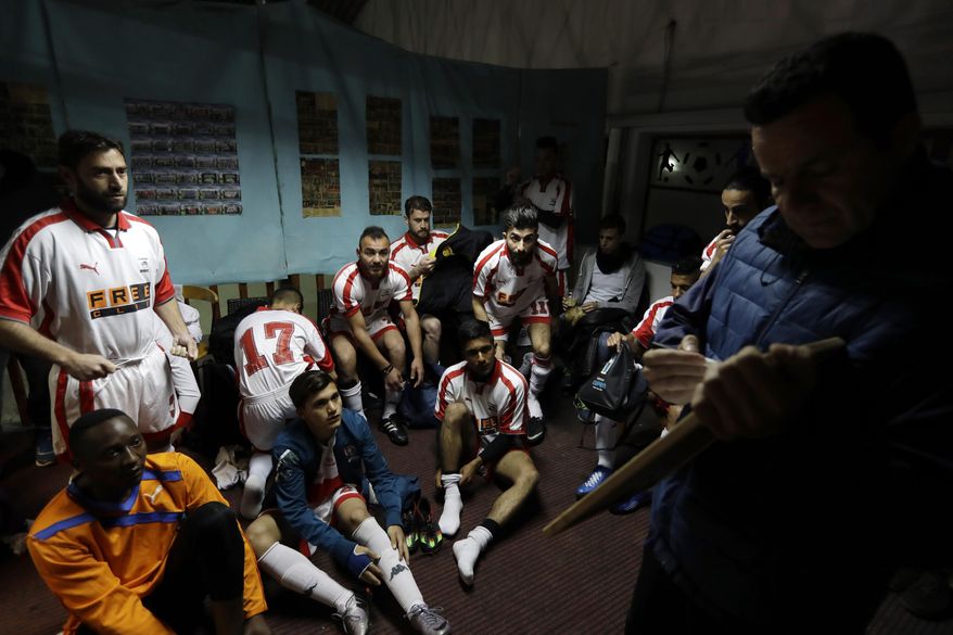 FOR STORY: GREECE TEAM CALLED HOPE - In this Sunday, Feb. 5, 2017, coach of Hope Refugee Football Club Antreas Sampanis, right, gives directions to his players before a soccer match in western Athens. On weekends they play in an amateur league against teams made up of professional groups like lawyers, telecom workers, and accountants. (AP Photo/Thanassis Stavrakis)