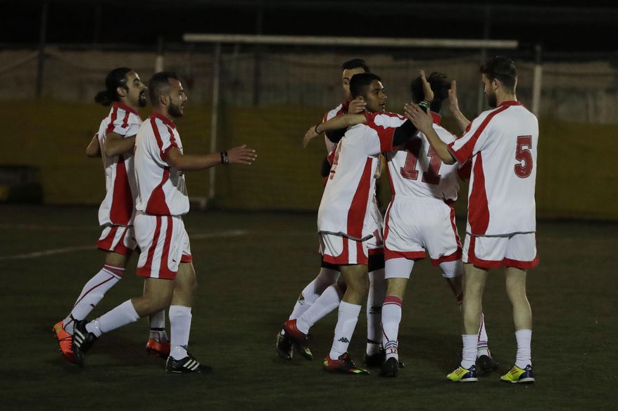 FOR STORY: GREECE TEAM CALLED HOPE - In this photo dated Sunday, Feb. 5, 2017, players of Hope Refugee Football Club celebrate a goal during a soccer match in western Athens. Former Greek national soccer team goalkeeper Antonis Nikopolidis, who became a national hero in 2004 during the European Cup, is heading a project to help refugees stranded in Greece regain a sense of purpose, working as a team. On weekends they play in an amateur league against teams made up of professional groups like lawyers, telecom workers, and accountants. (AP Photo/Thanassis Stavrakis)