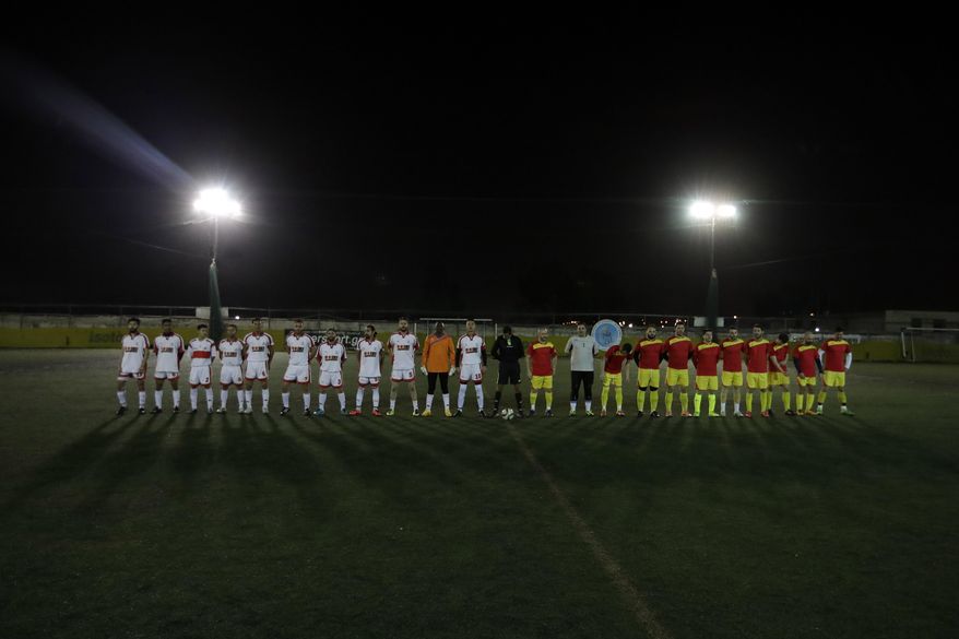 FOR STORY: GREECE TEAM CALLED HOPE - In this Sunday, Feb. 5, 2017, Hope Refugee Football Club, left, and 3D Team of Hellenic American University Football Club posing for photo before a soccer match in western Athens. Former Greek national soccer team goalkeeper Antonis Nikopolidis, who became a national hero in 2004 during the European Cup, is heading a project to help refugees stranded in Greece regain a sense of purpose, working as a team. On Sundays they play in an amateur league against teams made up of professional groups like lawyers, telecom workers, and accountants. (AP Photo/Thanassis Stavrakis)