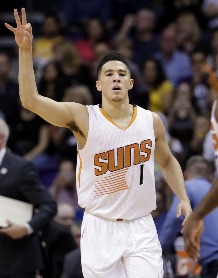 Phoenix Suns guard Devin Booker signals after making a 3-pointer against the Los Angeles Lakers during the first half of an NBA basketball game, Wednesday, Feb. 15, 2017, in Phoenix. (AP Photo/Matt York)
