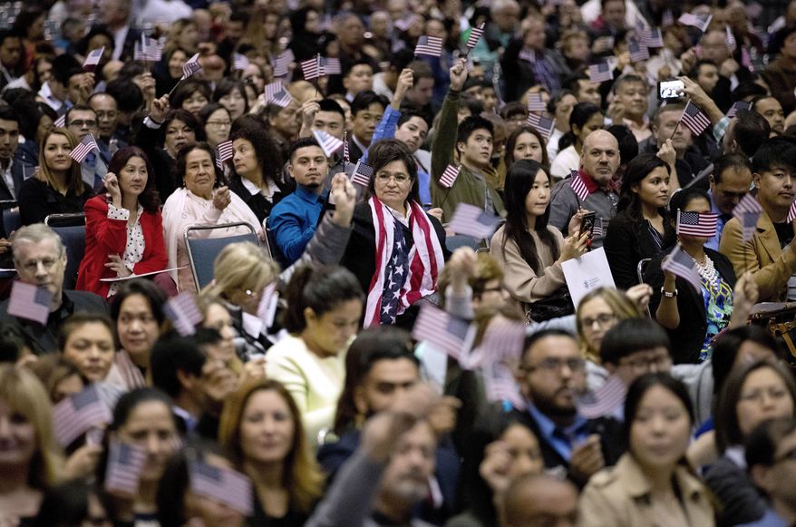 People wave U.S. flags during a naturalization ceremony at the Los Angeles Convention Center, Wednesday, Feb. 15, 2017, in Los Angeles. About 3,000 people took the oath in the morning and more than 3,500 others were expected during an afternoon ceremony, according to U.S. Citizenship and Immigration Services officials. (AP Photo/Jae C. Hong)