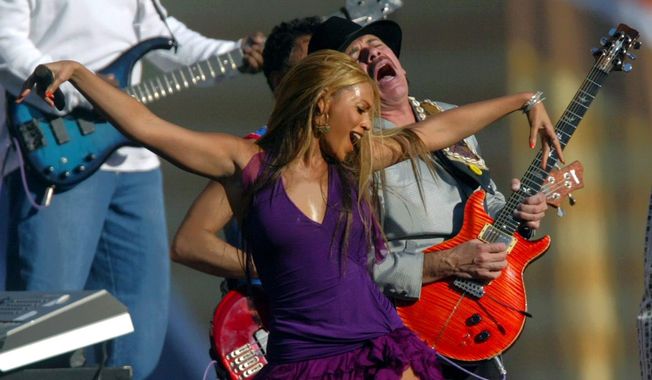 FILE - In this January 26, 2003, file photo, Beyonce and guitarist Carlos Santana perform for the pre-game show before the start of Super Bowl XXXVII in San Diego. Santana said on Facebook Feb. 14, 2017, that he was only trying to congratulate Adele on her big night at the Grammys when he told the Australian Associated Press that Beyonce “is very beautiful to look at,” but “she’s not a singer, singer.” (AP Photo/Lawrence Jackson, File)