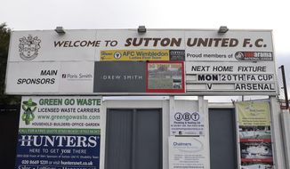 A sign advertising Sutton United&#x27;s next fixture, which is against Arsenal on Monday 20th Feb, 2017 at Gander Green Lane, London, Thursday Feb. 16, 2017. Sutton United, the fifth-tier semiprofessional team will play Arsenal, the 13-time English champions, after reaching the fifth round of the FA Cup competition for the first time in its 118-year history on Monday Feb. 20, (Andrew Matthews/PA via AP)