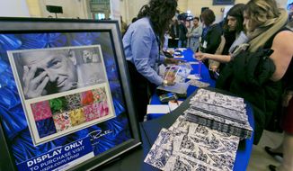 Commemorative stamps honoring the late fashion designer Oscar de la Renta are displayed for sale after an unveiling at  Grand Central Terminal in New York, Thursday, Feb. 16, 2017. (AP Photo/Richard Drew)