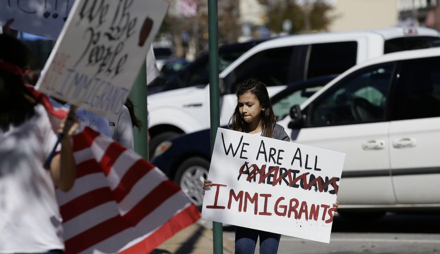 Allison Perez, 9, holds a sign as she marches with others during a protest outside the Grayson County courthouse in downtown Sherman, Texas, Thursday, Feb. 16, 2017. In an action called "A Day Without Immigrants," immigrants across the country are expected to stay home from school, work and close businesses to show how critical they are to the U.S. economy and way of life. (AP Photo/LM Otero)