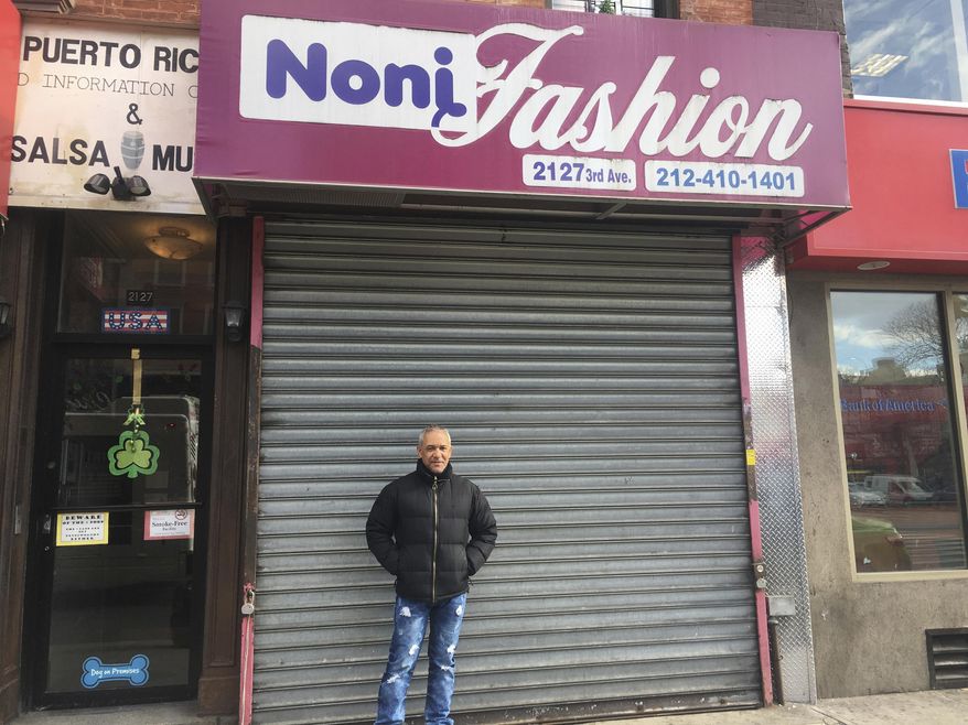 Custo Diaz poses in front of his closed shop, Noni Fashion, a women's clothing store at 116th Street in the East Harlem neighborhood of New York, on Thursday Feb. 16, 2017. He was participating in the boycott called A Day Without Immigrants, aimed squarely at President Donald Trump's efforts to crack down on immigration. Diaz, a Dominican immigrant, said he closed his shop in support of all the immigrants who are "feeling attacked" these days. Diaz said he has lived for 40 years in the U.S. and he stands in solidarity with his "undocumented brothers and sisters." (AP Photo/Claudia Torrens)