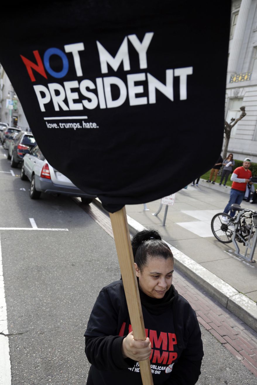 A demonstrator waves a t-shirt during a protest against President Donald Trump's efforts to crack down on immigration Thursday, Feb. 16, 2017, in San Francisco. Immigrants around the country have been staying home from work and school today, hoping to demonstrate their importance to America's economy and its way of life. (AP Photo/Marcio Jose Sanchez)