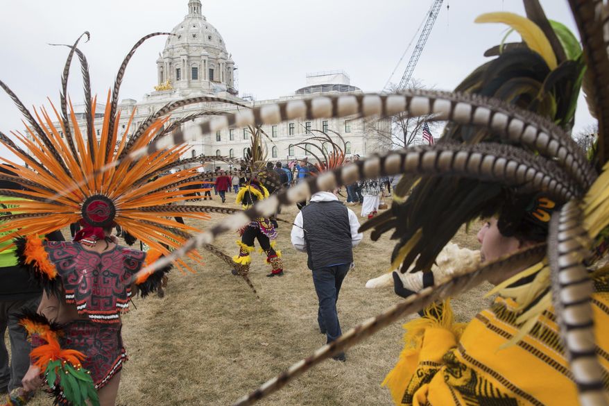 Indigenous dancers lead a group of "A Day Without Immigrants" protesters up to the steps of the Minnesota State Capitol on Thursday, Feb. 16, 2017, in St. Paul, Minn. It was part of a nationwide rally designed to show how important immigrants are to daily life. (Evan Frost/Minnesota Public Radio via AP)