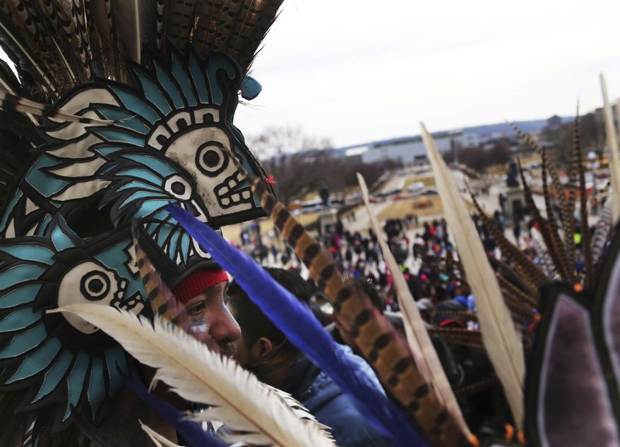 Participants in the "A Day Without Immigrants," including dancers from Mexica Yolotl, a traditional Aztec group of Mexico-Americans from the Twin Cities, head inside the Minnesota State Capitol after marching from the Mexican consulate Thursday, Feb. 16, 2017, in St. Paul, Minn. Immigrants around the U.S. stayed home from work and school Thursday to demonstrate how important they are to America’s economy and way of life, and many businesses closed in solidarity, in a nationwide protest called A Day Without Immigrants. (David Joles/Star Tribune via AP)