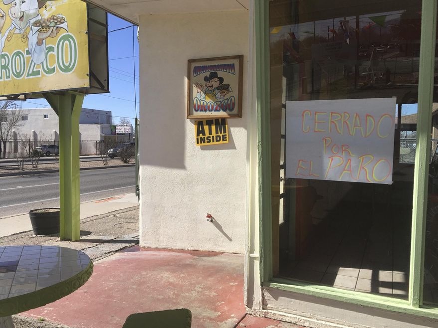 A sign outside the Mexican restaurant Chicharroneria Orozco in Albuquerque's South Valley on Thursday, Feb. 16, 2017, Albuquerque, N.M., announces that the store is closed in solidarity with a nationwide protest called A Day Without Immigrants. Immigrants around the U.S. stayed home from work and school Thursday to demonstrate how important they are to America's economy and its way of life, and many businesses closed in solidarity. (AP Photo/Russell Contreras)