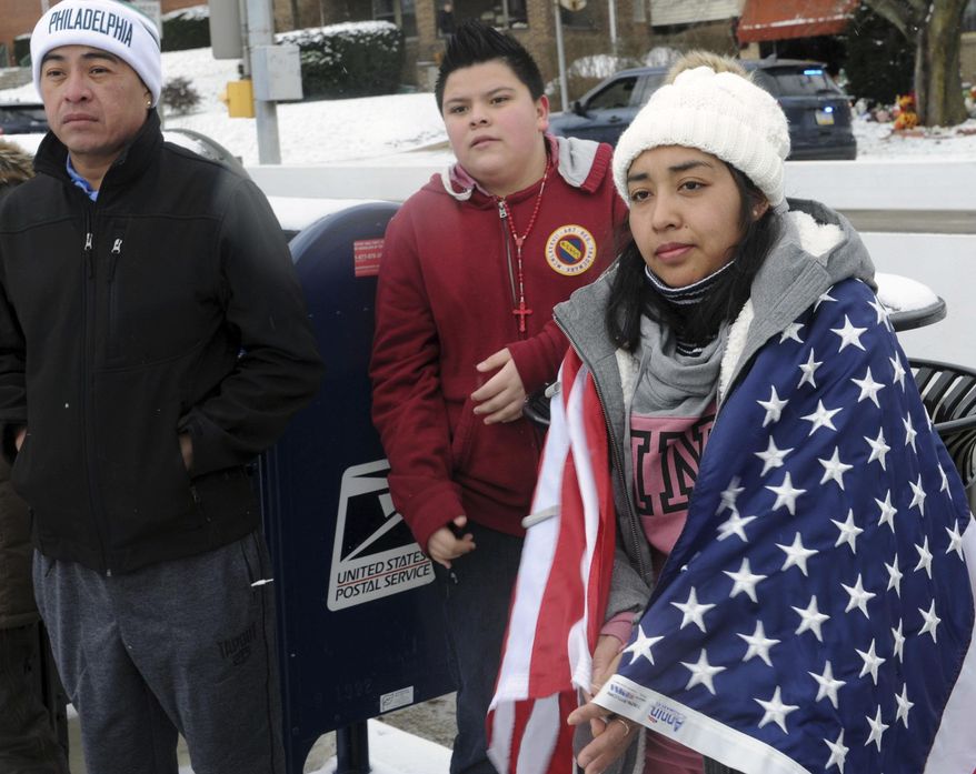 Brandeli Rojas of Beechview listens to one of the speakers during a rally in Pittsburgh's Beechview neighborhood, Thursday Feb. 16, 2017, protesting the recent crackdowns on immigrants ordered by President Donald Trump. Several dozen area residents marched down Broadway Avenue, Thursday Feb. 16, 2017, in one of the "Day Without Immigrants" protests being held across the United States. (Nate Guidry/Pittsburgh Post-Gazette via AP)