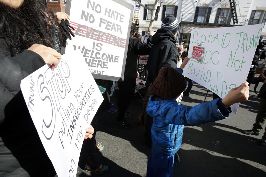 Marcela Ardaya-Vargas, left, who is from Bolivia and now lives in Falls Church, Va., holds a sign with her son during a Day Without Immigrants protest, Thursday, Feb. 16, 2017, in Washington. (AP Photo/Alex Brandon)